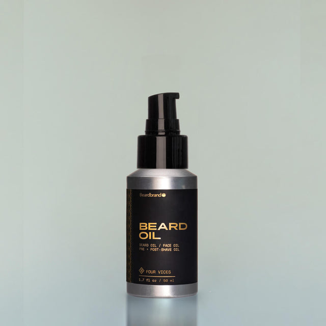 A bottle of Four Vices travel-size Beard Oil with a pump dispenser against a grey background.