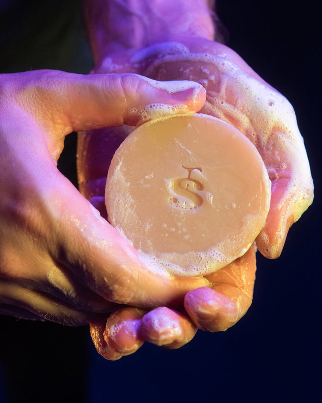 A person sudsing up a Beardbrand Old Money Utility Bar in their hands.