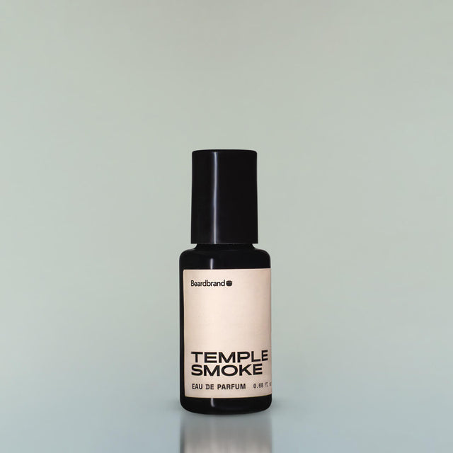 A bottle of Temple Smoke Eau de Parfum against a grey background.