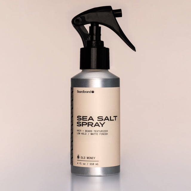 A bottle of Sea Salt Spray with a sprayer dispenser against a neutral background.