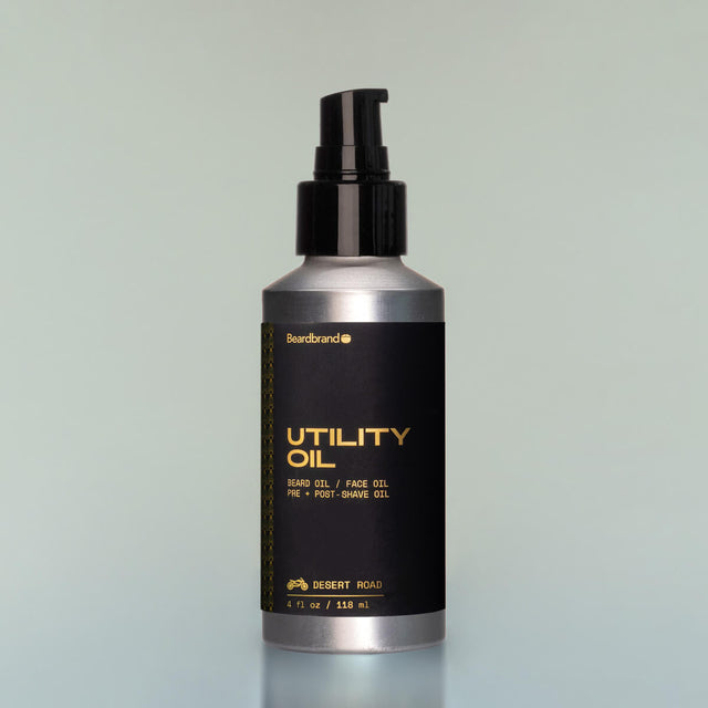 A bottle of Desert Road Utility Oil with a pump dispenser against a grey background.