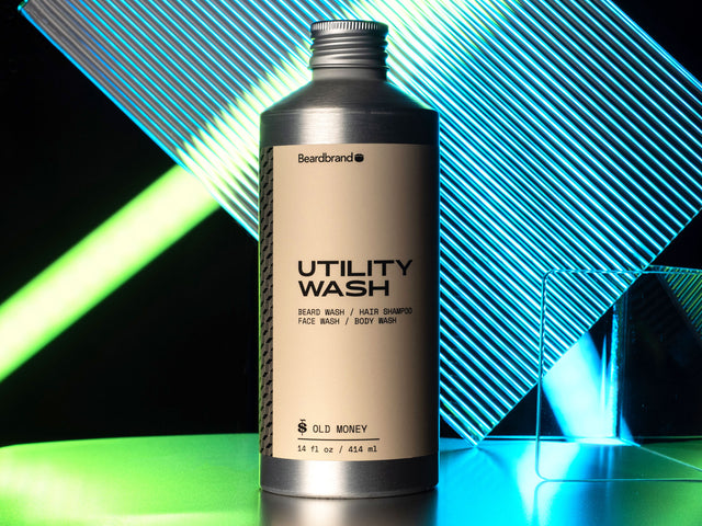 Utility Wash in aluminum packaging against a green and blue neon backdrop.