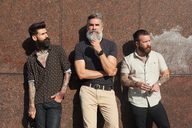 Three beardsmen—Carlos, Greg & Jeff lined up against a wall of large granite tiles.