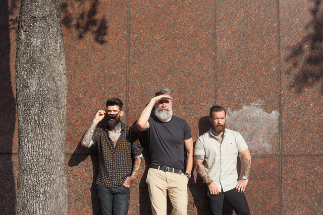 Carlos Costa, Greg Berzinsky, and Jeffrey Buoncristiano have awesome beards and they are standing together outside. 