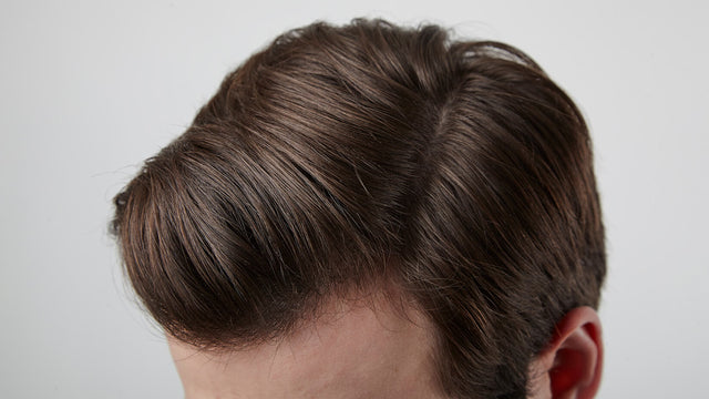 Close up of a white male's stylish brown, side-parted hair after using shampoo and conditioner. 