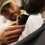 A close-up of a barber shaping a client’s beard with electric clippers, focusing on detail and craftsmanship.