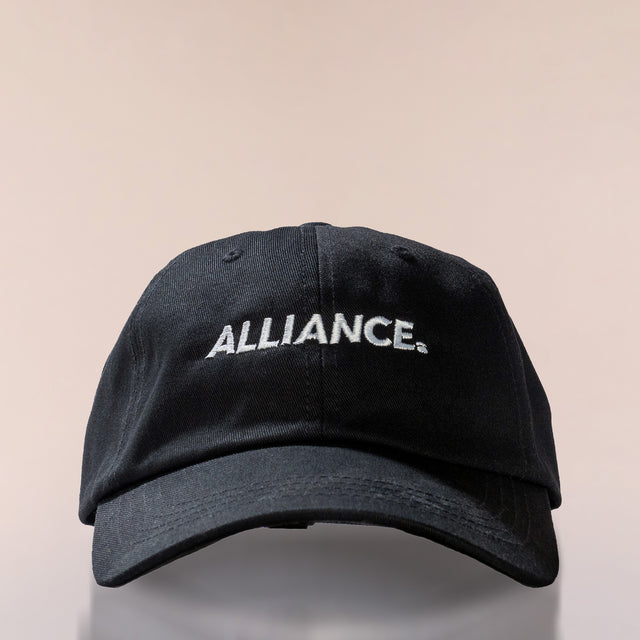 The Alliance Dad Hat in black 100% cotton twill with the logo embroidered in white—front view.