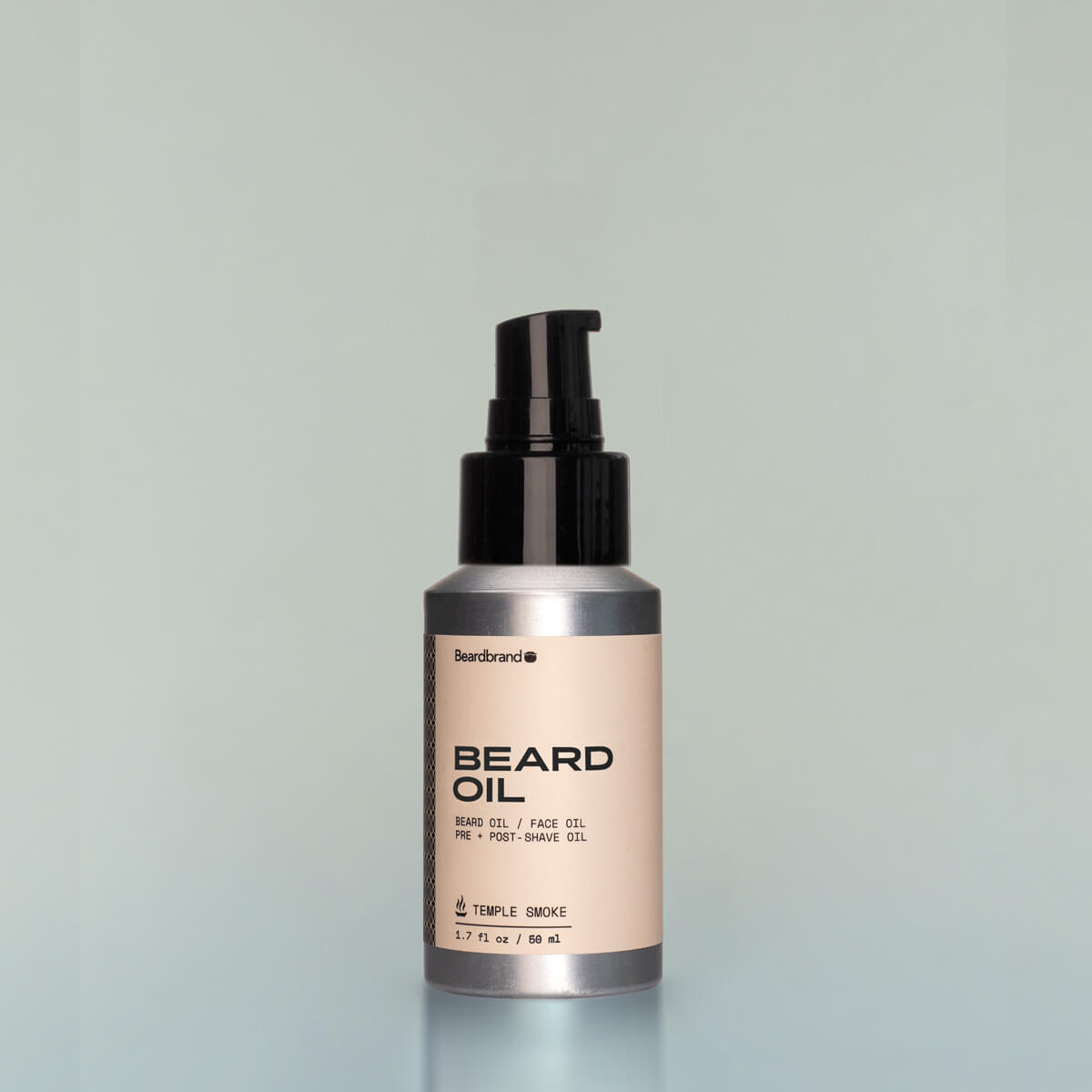 A bottle of Temple Smoke travel-size Beard Oil with a pump dispenser against a grey background.