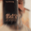 Bearded man applying Beardbrand Black Sails Cologne rollerball to his neck and showing the bottle.