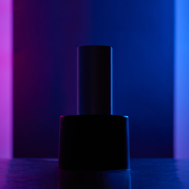 Sleek cylindrical product teaser silhouette against a darkened blue and purple gradient background.