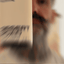 Bearded man applying Beardbrand Desert Road Cologne rollerball to his neck and showing the bottle.