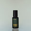 A bottle of Short Game Eau de Parfum against a grey background.