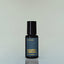 A bottle of Worn Denim Eau de Parfum against a grey background.