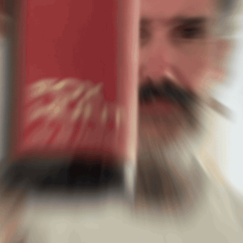 Bearded man applying Beardbrand Fox Hunt Cologne rollerball to his neck and showing the bottle.