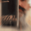 Bearded man applying Beardbrand Ghost Tracer Cologne rollerball to his neck and showing the bottle.