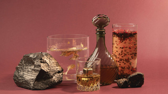 A still life of items reminiscent of Old Money’s fragrance notes: glasses of various liquids with gold flakes and cubes hovering inside.