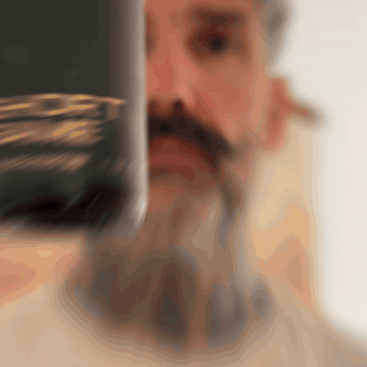 Bearded man applying Beardbrand Short Game Cologne rollerball to his neck and showing the bottle.