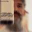 Bearded man applying Beardbrand Temple Smoke Cologne rollerball to his neck and showing the bottle.