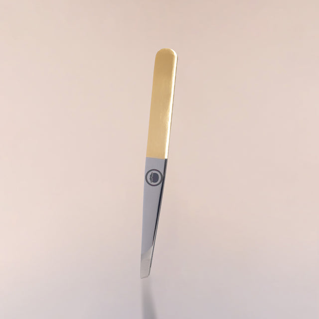The slant tip Beardbrand Tweezers with two-tone stainless steel and the Beardbrand circle logo against a neutral background.