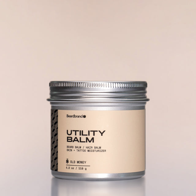 A container of Old Money Utility Balm against a neutral background.