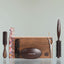 Beardbrand grooming tools lined up and leaning against a wooden Beardbrand Beardsman’s Box.