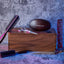 Grooming tools on and around a wooden box against a textured wall, including brushes, scissors, and combs.