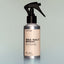A bottle of Old Money Sea Salt Spray with a sprayer dispenser against a grey background.