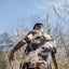 Carlos walking away from the camera in a wild field.