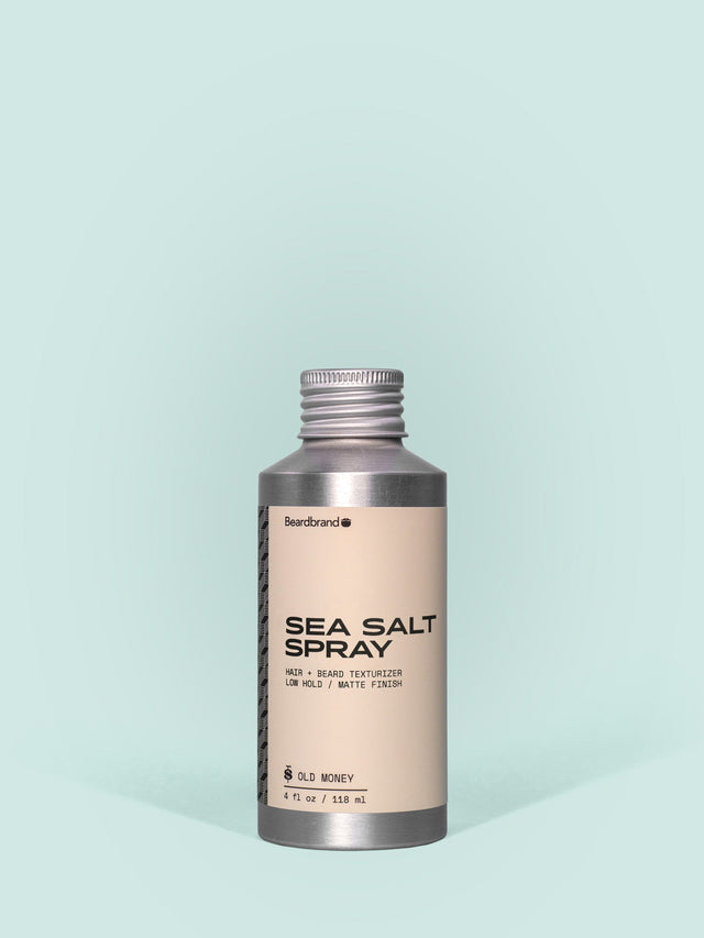 Beardbrand Sea Salt Spray in Aluminum packaging with a screw cap against a light blue background.